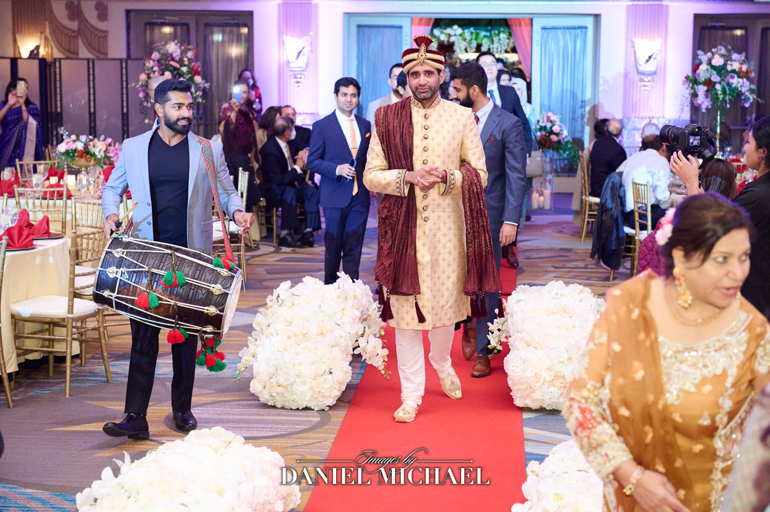 South Asian Muslim groom in traditional attire leading the processional at the Hilton Hall of Mirrors in Cincinnati during a wedding ceremony